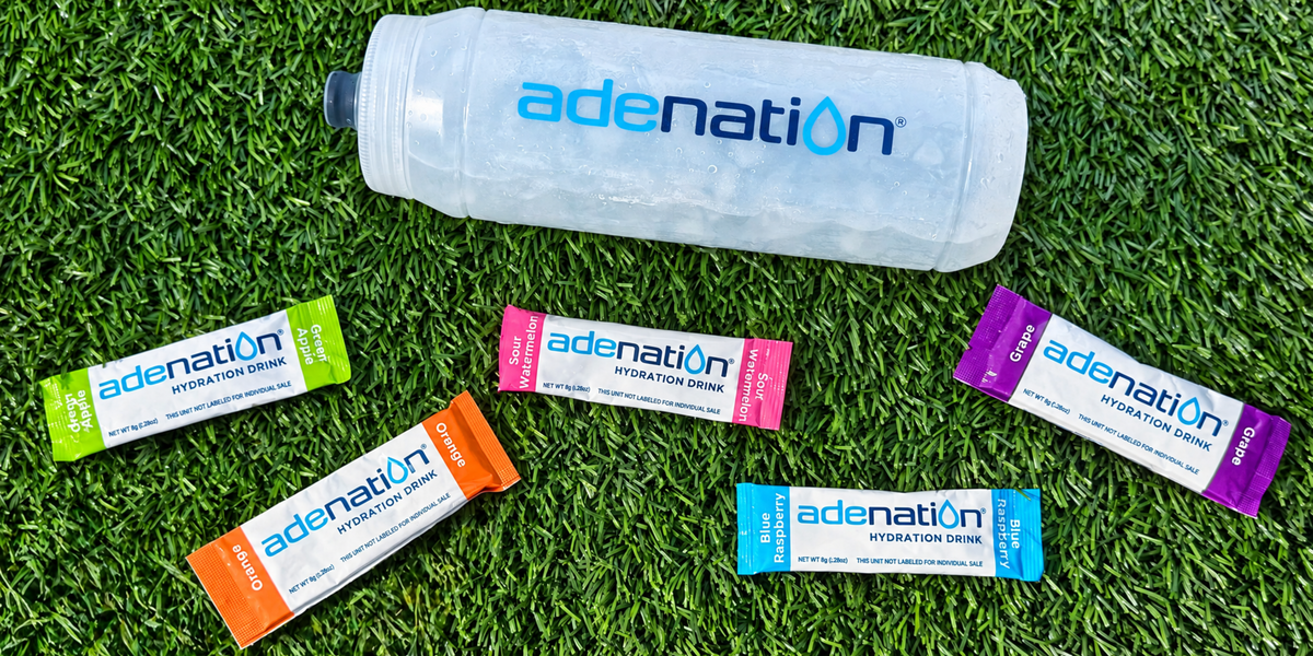 AdeNation bottle and all five flavor sticks on turf